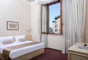 una camera d'albergo con letto e finestra di Hotel Ercolini & Savi a Montecatini Terme