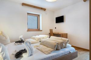 a room with four pillows on a bed at Planerhof Apartment Enzian in Funes