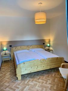 um quarto com uma cama de madeira e 2 mesas em Appartamento Piè em Canazei