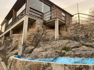 uma casa no topo de uma montanha com uma varanda em casa da alegria em Urgueira