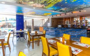 a restaurant with tables and chairs and a large aquarium at Relax Beach Hotel in Alanya