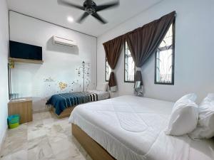 Ks Homestay في تايبينغ: غرفة نوم بسريرين ومروحة سقف
