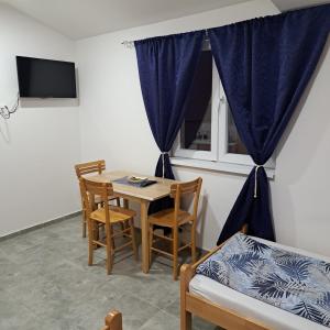 a room with a table and chairs and a window at LIBERO APARTMANI in Surčin