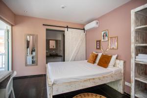 a bedroom with a bed with white sheets and orange pillows at BOHO Bohemian Boutique Hotel in Willemstad