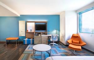a living room with blue walls and a table and chairs at EVEN Hotel Miami - Airport, an IHG Hotel in Miami