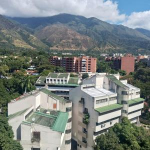una ciudad con edificios y montañas en el fondo en RIVERA SUITE, en Caracas