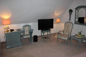 a living room with a television and two chairs at Hotel & Restaurant Zum Vater Rhein in Monheim