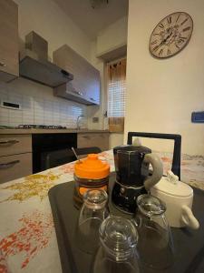 una cucina con tavolo, macchinetta del caffè e orologio di Fantastico appartamento a pochi passi dalla metro a Torino