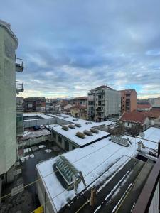 una città con neve sui tetti degli edifici di Fantastico appartamento a pochi passi dalla metro a Torino
