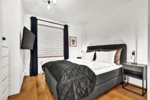 a bedroom with a large bed and a window at Tjuvholmen II, As Home in Oslo