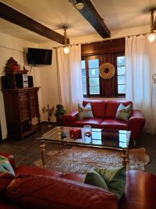 a living room with a red couch and a coffee table at Pilgrims Gästeapartements in Meschede