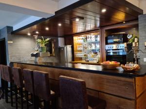 a bar in a restaurant with a counter and chairs at Pilgrims Gästeapartements in Meschede