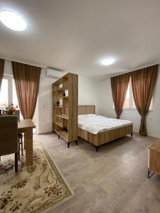 a bedroom with a large bed and a desk at White Apartments in Kosovo Polje