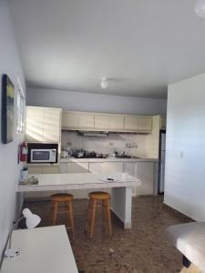 a kitchen with a counter and two stools in it at CRAB ISLAND ADVENTURES APARTMENTS in Vieques