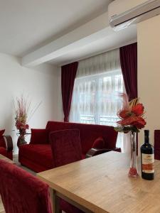 a living room with a table and a red couch at White Apartments in Kosovo Polje +12 photos