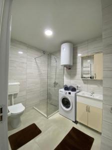 a bathroom with a washing machine and a sink at White Apartments in Kosovo Polje