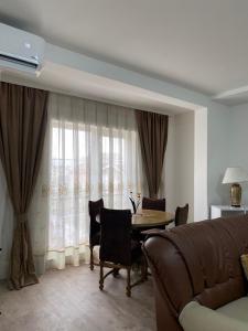 a living room with a table and a couch at White Apartments in Kosovo Polje
