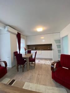 a living room with a table and a red couch at White Apartments in Kosovo Polje