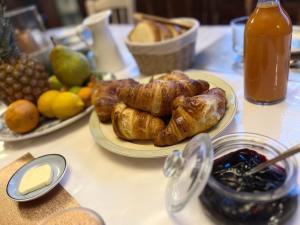 - une table avec des assiettes de croissants et d'autres aliments pour le petit-déjeuner dans l'établissement Mercier de Montigny - Les Chambres du Beffroi - SPA et Massage, à Fougères