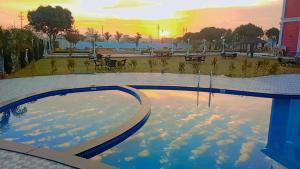 een weerspiegeling van de lucht in een zwembad bij The Kamoda Resort in Ambikāpur
