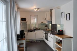 a kitchen with white cabinets and a large window at Auszeit am Meer in Zierow