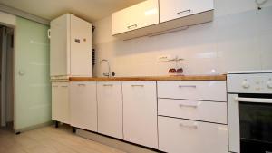 a kitchen with white cabinets and a sink at Holiday Home Bili Žal in Vela Luka