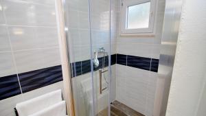a bathroom with a shower with a glass door at Holiday Home Bili Žal in Vela Luka