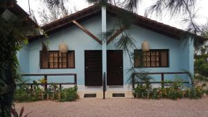 a blue house with brown doors and windows at Moony’s Chalets & Camping in Catembe