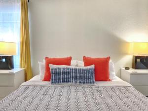 a bedroom with a bed with orange and blue pillows at Pet-friendly Duplex, Big Shared Yard in Charming Historic Travis Heights! in Austin