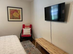 a room with a bed and a flat screen tv on the wall at Pet-friendly Duplex, Big Shared Yard in Charming Historic Travis Heights! in Austin