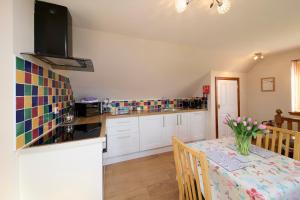 a kitchen with a table with a vase of flowers on it at The Mews Apartment at Daviot Lodge in Inverness