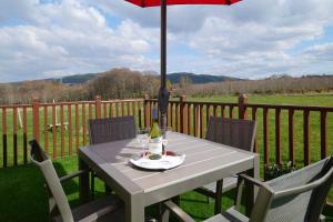 a picnic table with an umbrella on a deck at The Mews Apartment at Daviot Lodge in Inverness
