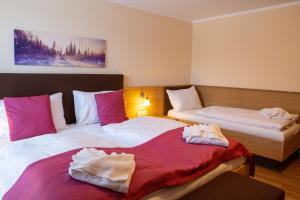Dos camas en una habitación de hotel con toallas. en Nassfeld Frühstückspension Wulfenia da Livio en Passo Pramollo