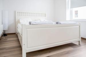 uma cama branca num quarto branco com uma estrutura de cama em Family friendly, Free Parking, in Best Part of the City em Ålesund