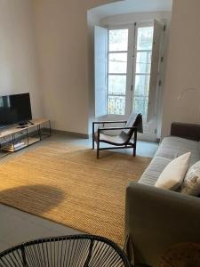 a living room with a couch and a tv at GALLE - Apartamento dos Infantes in Beja