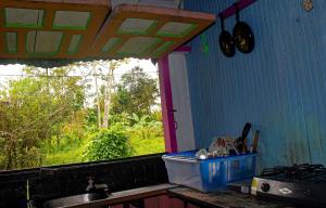 une cuisine avec une fenêtre et un comptoir avec un évier dans l'établissement Hostal Bahía Solano Herping, à El Valle