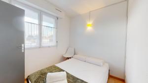 une petite chambre avec un lit et une fenêtre dans l'établissement Appartement Les Embruns, à Les Bussolleries