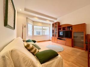 a living room with a couch and a tv at Prop de mar a 60m de la playa in Calafell
