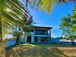 a house with a palm tree in front of it at Casa Pé na Areia - Jacumã, Vista Mar, Wi-Fi by PenareiaTurBr in Conde