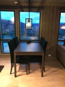 une table à manger avec des chaises et un lustre dans l'établissement Vangslia, Oppdal. Lekker leilighet med ski inn/ski ut, à Oppdal