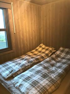 Una cama en una habitación con una manta. en Vangslia, Oppdal. Lekker leilighet med ski inn/ski ut en Oppdal