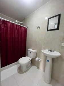 y baño con aseo y cortina de ducha roja. en 2CB-3 APARTAMENTO DE 2 ALCOBAS EN EL CENTRO HISTORICO CON AIRE ACONDICIONADO Y WIFI en Cartagena de Indias