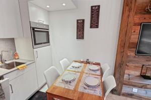 クランにあるAppartement cosy au centre de la stationのキッチン(テーブル、白い椅子付)、シンク付きのキッチン +23枚の写真