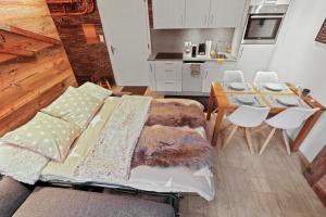 クランにあるAppartement cosy au centre de la stationのソファとテーブルとキッチンのあるリビングルーム