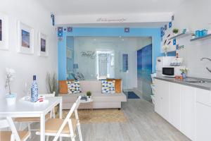 a kitchen and a living room with a table and chairs at Chez Downtown Charm - Your Seaside Dream! in Lagos +29 photos