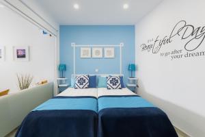 a bedroom with a bed with a blue wall at Chez New Best Charm e Design - Your Seaside Dream! in Lagos