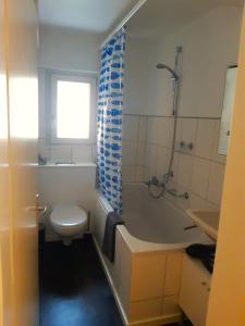 uma casa de banho com um WC, uma banheira e um lavatório. em Interlaken City Apartments em Interlaken