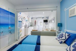 a blue and white bedroom with a bed and a bathroom at Chez Downtown Charm - Your Seaside Dream! in Lagos