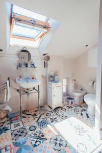 a bathroom with a sink and a toilet and a skylight at B&B en Provence- Villa Saint Marc in Forcalquier