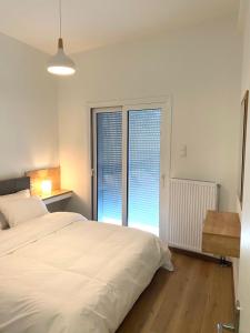 a bedroom with a large bed and two large windows at Volos City Center 1 in Volos